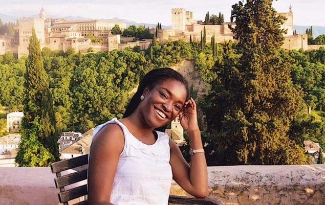 Somto Ugwueze, founder of Destination Forward LLC, smiles in front of a scenic background